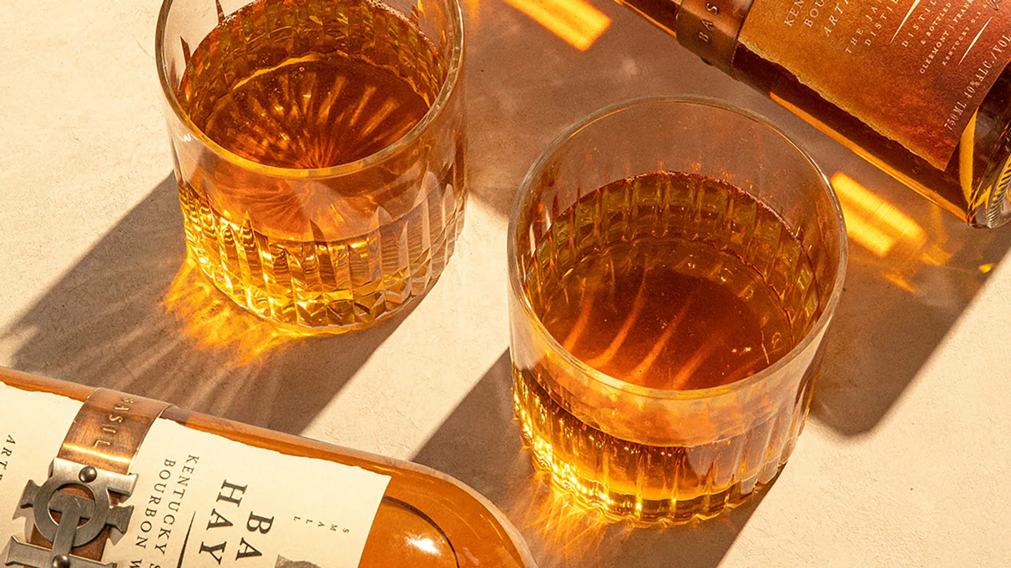 basil hayden bourbon bottle with glass on a table